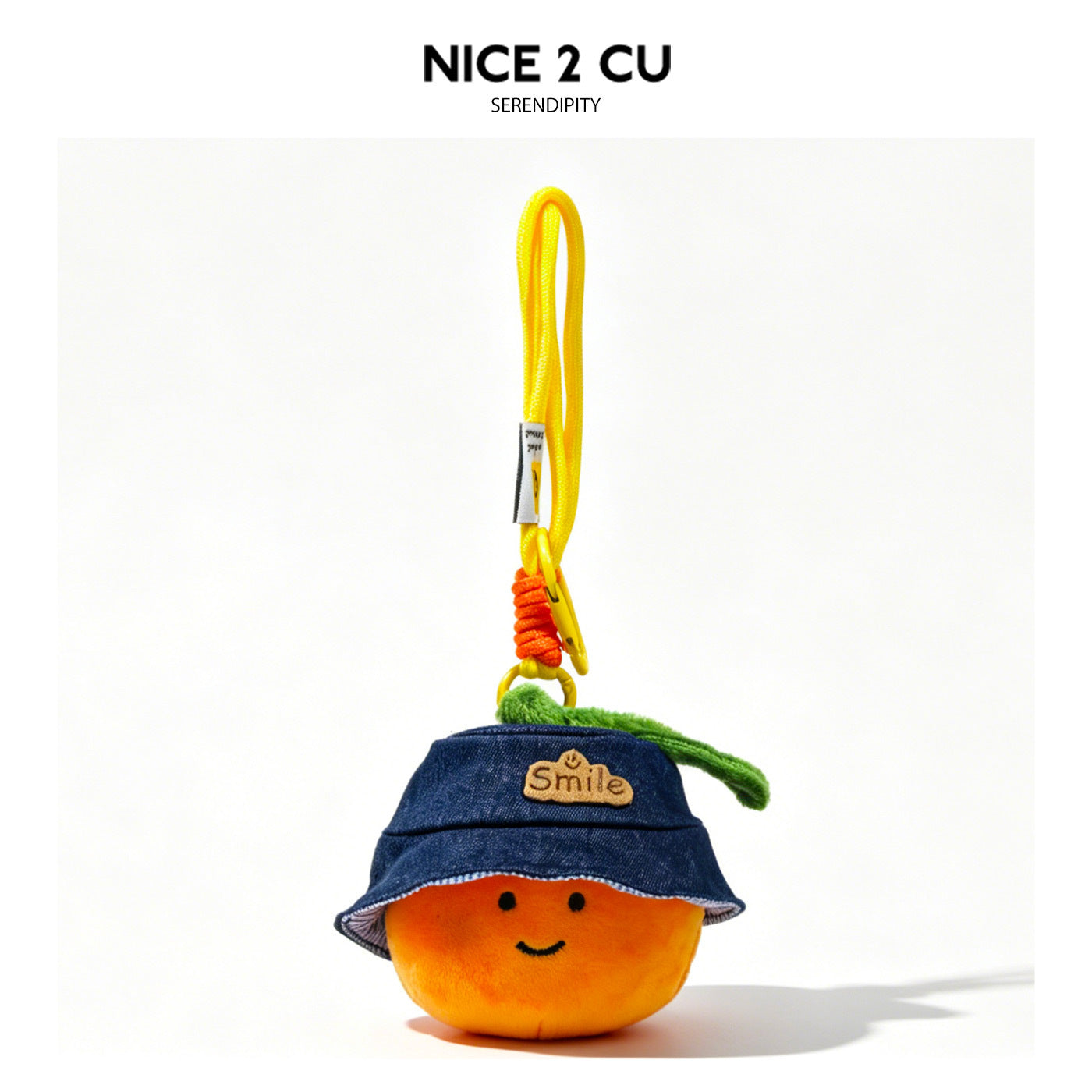 Smiling orange plush charm wearing a blue denim-look bucket hat with a Smile patch and green leaf detail on a yellow clip str