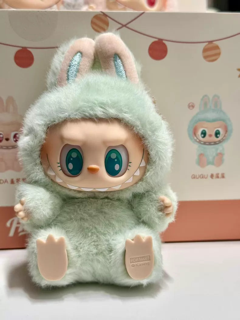 The POP MART Labubu “Ququ” Plush Keychain – Have a Seat Series Green Bunny sits before a bunny-themed box from The Monsters collection, both featuring Kasing Lung's playful designs.