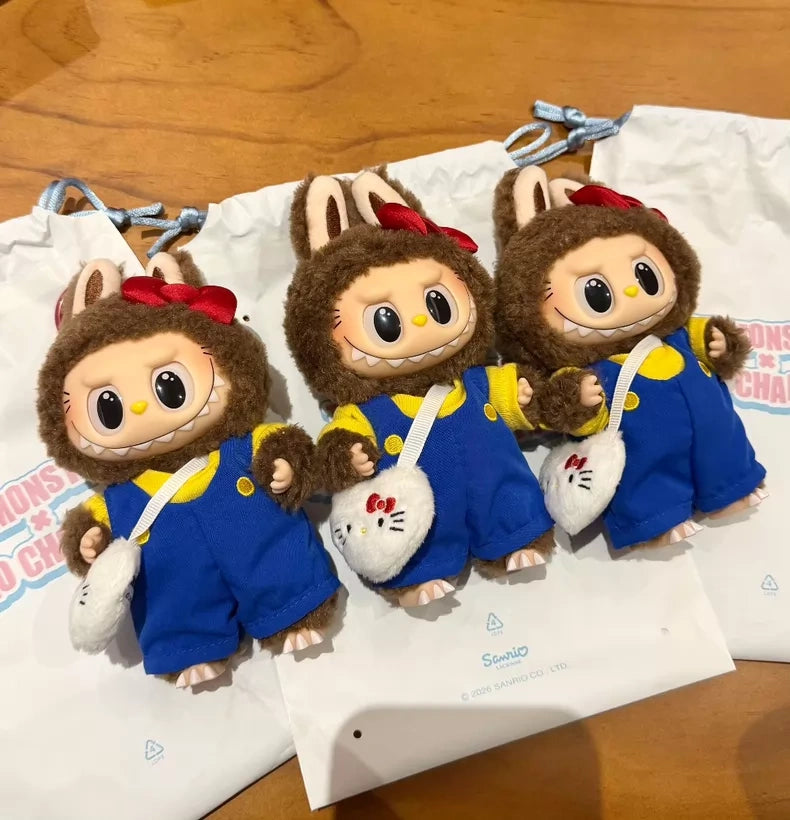 Three POP MART LABUBU Hello Kitty and Friends Series Secret Edition Plush Pendant Figures, each in blue overalls, brown bunny-eared hoods, red bows, and holding white Hello Kitty purses, are displayed before white drawstring bags.