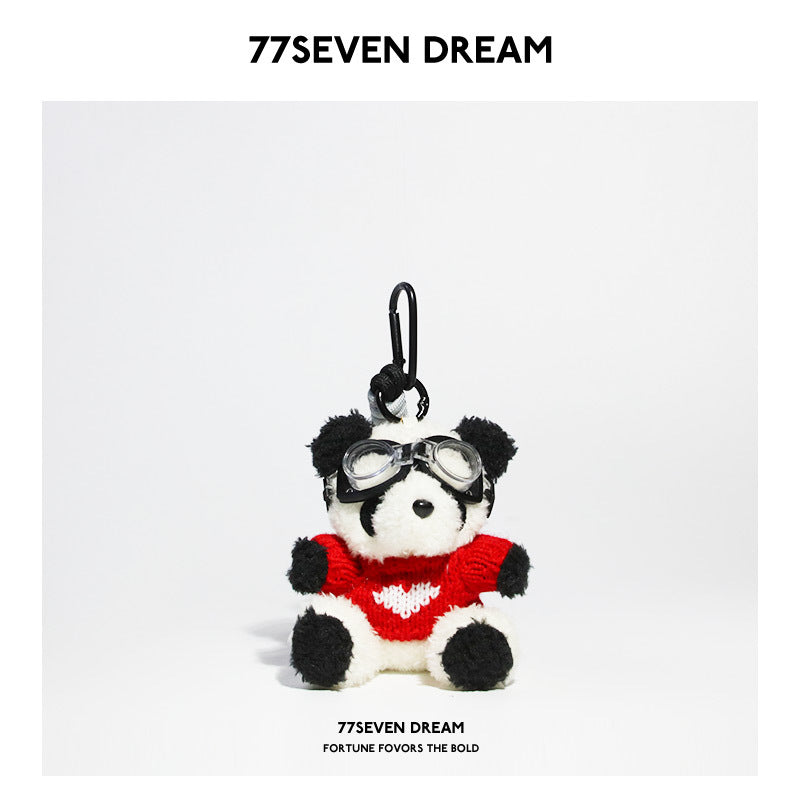 Seated panda bag charm with red knitted sweater featuring white heart motif and clear goggles