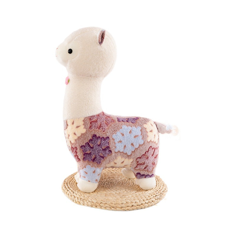 The ZoDoll Flower Alpaca Plush Toy, a soft stuffed alpaca plush doll with a pastel floral pattern, stands on a woven mat against a white background.