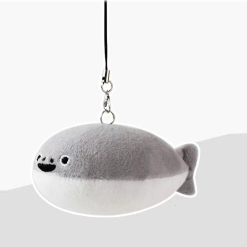 Gray and white fish-shaped plush keychain with smiling embroidered face and black loop strap