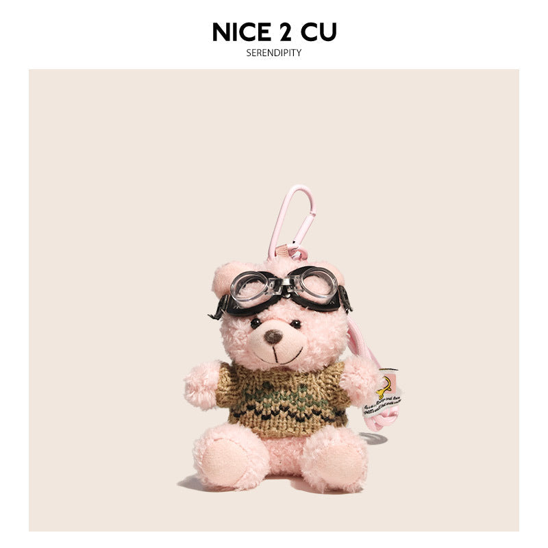 Pink teddy bear keychain charm with khaki knitted sweater and black aviator goggles