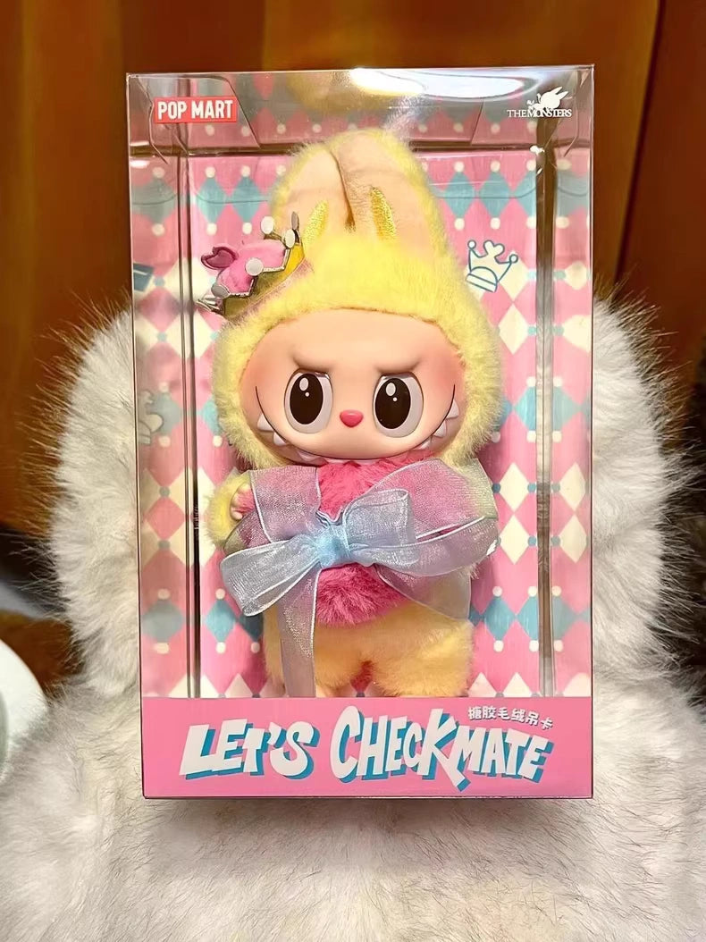The Labubu Let’s Checkmate Series – Pink Heart Bunny Plush Vinyl Doll by POP MART comes in a yellow bunny suit with a pink bow, packaged in a LETS CHECKMATE box with a pink and blue diamond pattern—a must-have collectible.