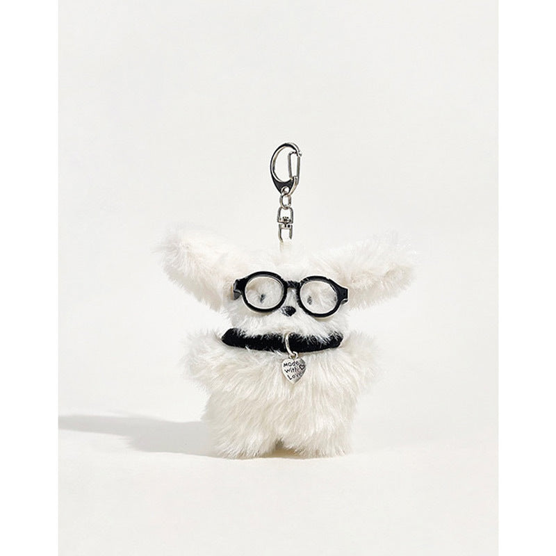 Fluffy white dog plush keychain charm with round black glasses and heart-shaped pendant