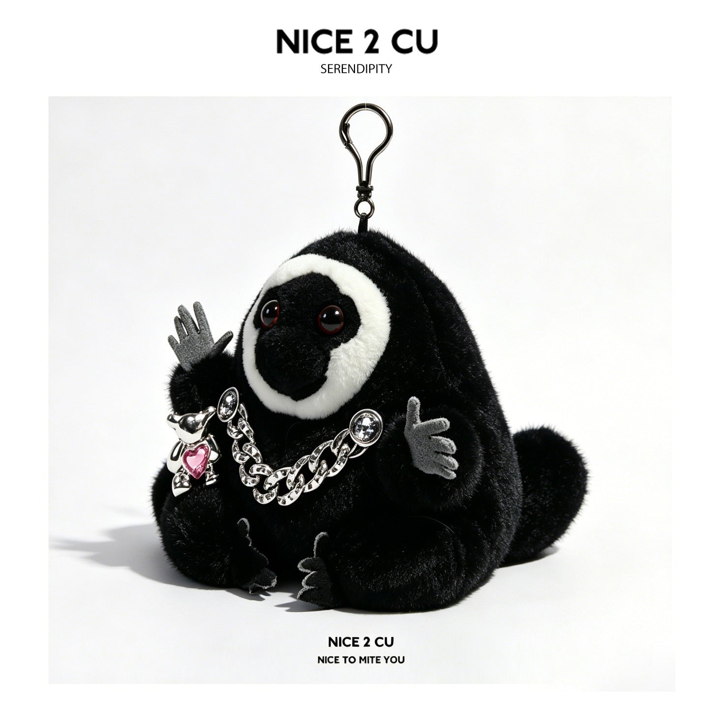 Serendipity Dudo black and white plush charm wearing a silver chunky chain necklace with pink heart gem pendant and swivel cl