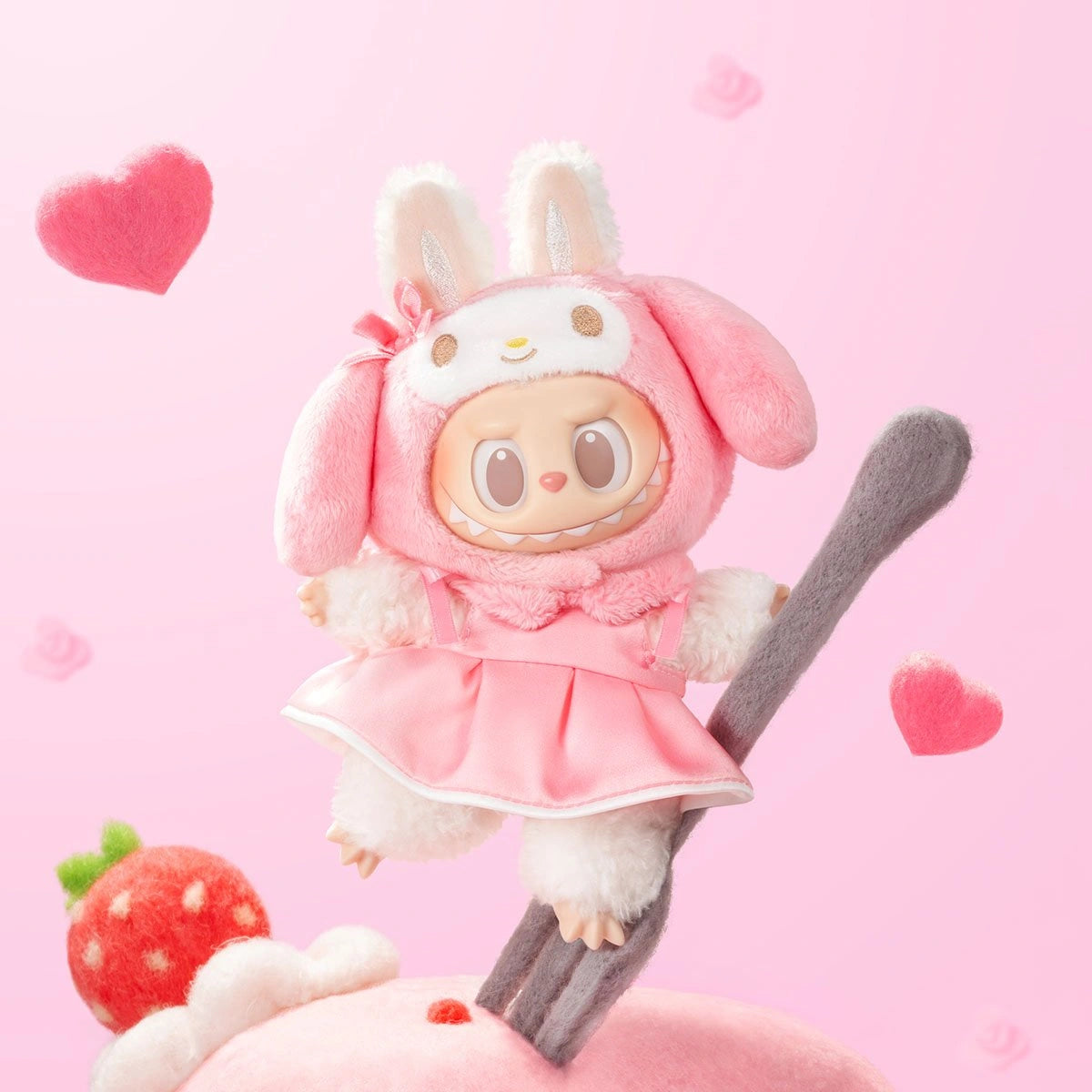 A cute POP MART LABUBU Hello Kitty and Friends Series My Melody Plush Pendant Figure, dressed in a pink bunny outfit, sits on a fork amid plush hearts and a strawberry—an adorable collectible for any Sanrio fan.