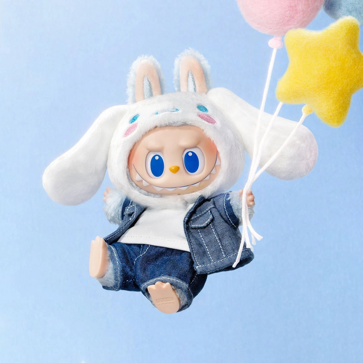 The POP MART LABUBU Hello Kitty and Friends Series Cinnamoroll Plush Pendant Figure features a kawaii accessory doll with big blue eyes, a white bunny-eared hat, denim jacket and jeans, holding felt balloons against a blue background.