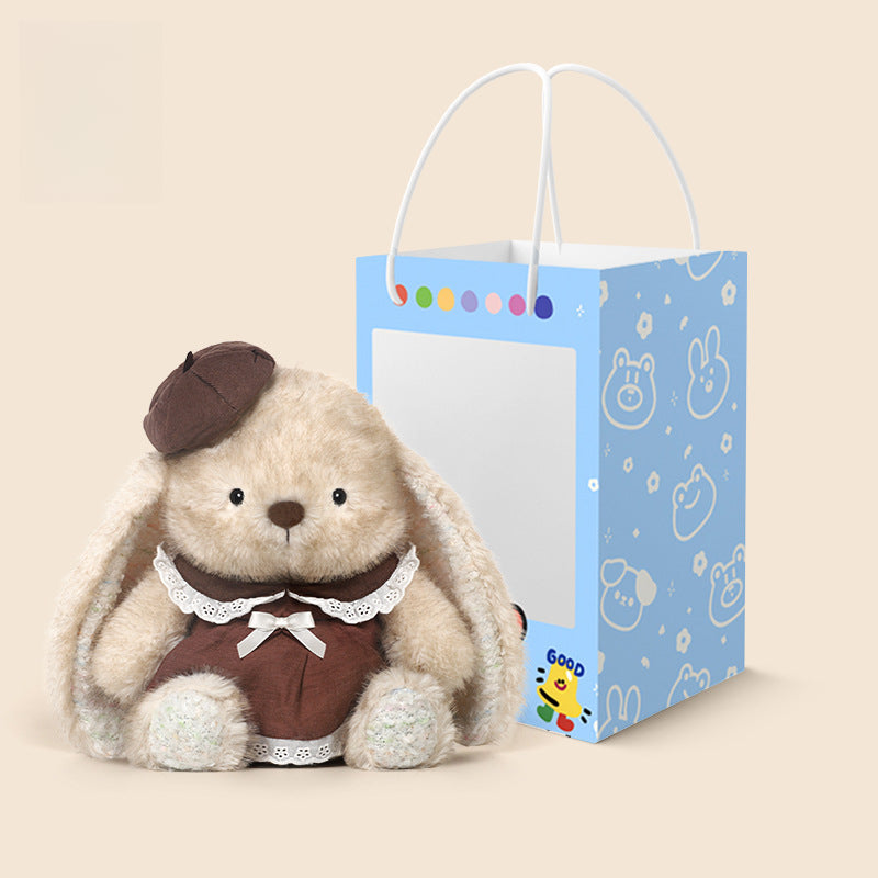A 35cm JOOKI Cute Bunny Plush Toy wearing a brown dress and beret sits next to a blue gift bag with cartoon animal faces and a Pikachu graphic.
