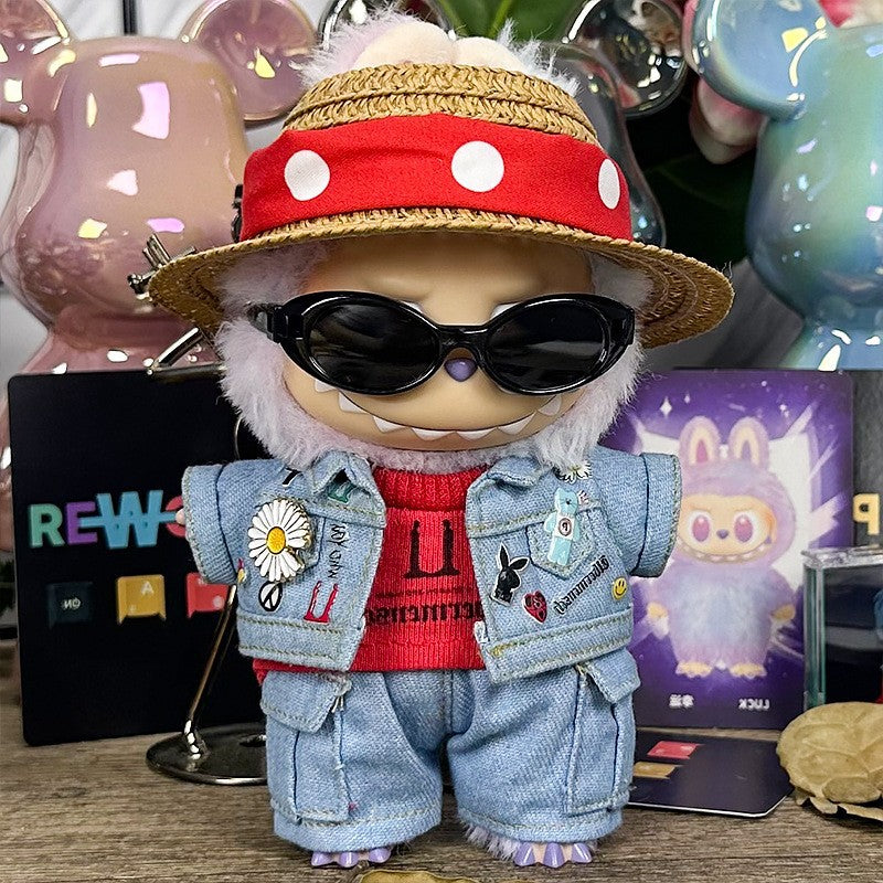 A ZoDoll Labubu wears the Cool Street Denim Jacket Outfit Set with a straw hat and sunglasses, featuring white fur and standing on a table with colorful objects in the background.