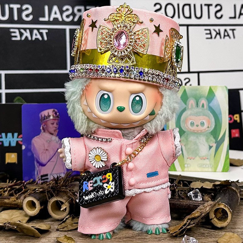 The ZoDoll Labubu Pink Royal Twill Suit Set features a plush toy in a royal twill suit with crown hat and mini bag, posed on a decorated surface with photo cards and more, highlighting its designer doll outfit charm.