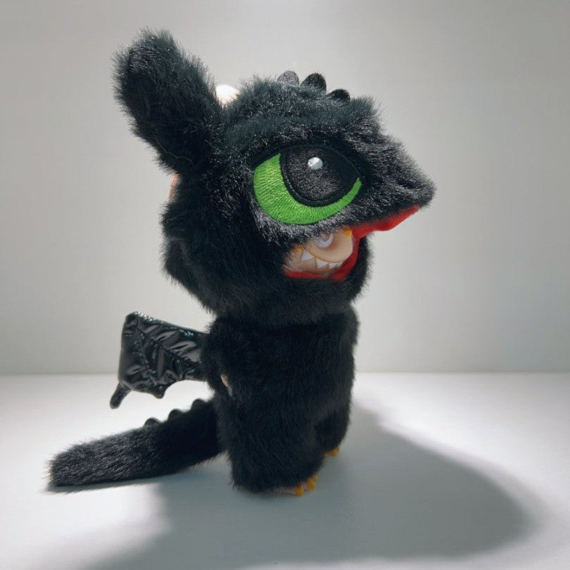The ZoDoll Labubu Night Fury Dragon Black Plush Full-Body Costume Outfit features a plush toy with large green eyes, white teeth, and black wings, dressed in black faux fur as a Night Fury dragon from How to Train Your Dragon.