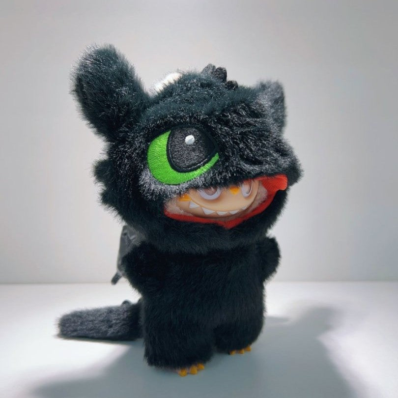 The ZoDoll Labubu Night Fury Dragon Black Plush, featuring large green eyes and an open red mouth with teeth, stands on a plain surface in its full-body costume outfit.