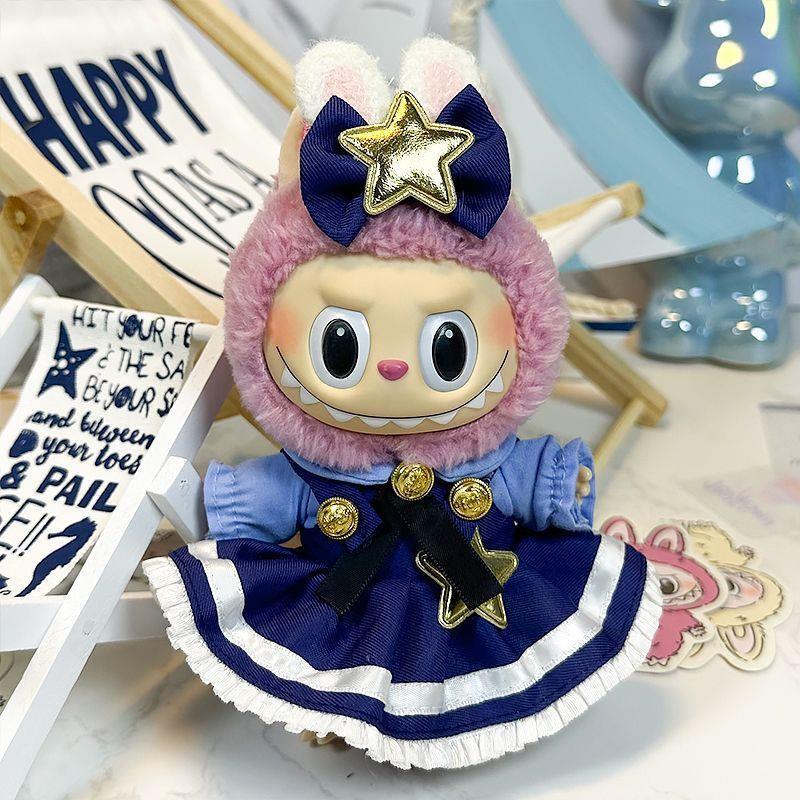 The ZoDoll Labubu Doll wears a navy blue Lolita dress with gold buttons, a gold star and bow, plus a pink hood featuring bunny ears and celestial star details.
