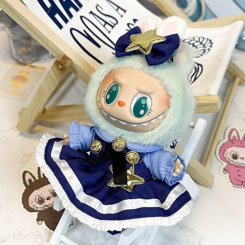 A ZoDoll Labubu doll in a navy blue Lolita dress with gold stars and a bow sits on a white chair, surrounded by character illustrations.