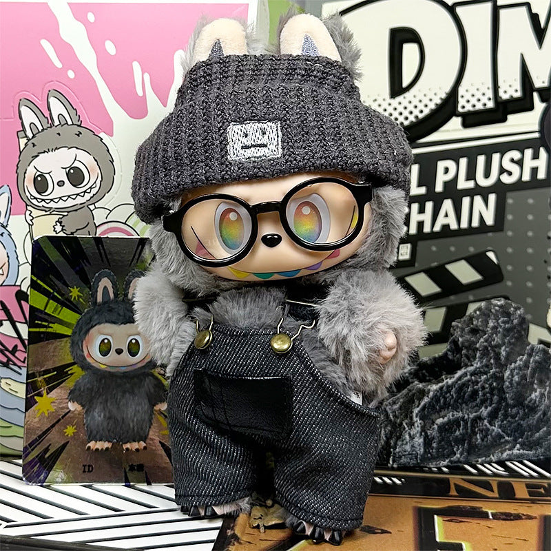 The ZoDoll Labubu Doll wears a gray fuzzy coat, dark denim overalls, and a knit beanie 3-piece set, standing before cartoon artwork with rainbow eyes and glasses, styled in trendy streetwear among other wolf-themed characters.