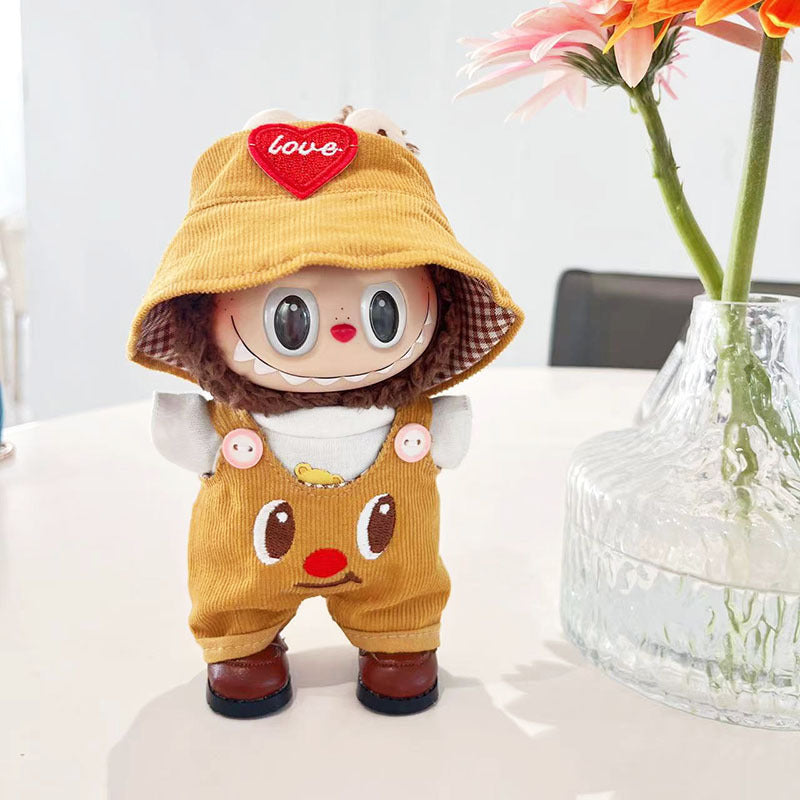 A ZoDoll stands on a white table next to a glass vase with orange flowers, dressed in the Labubu Olive Corduroy Overalls and Gingham Bucket Hat Doll Outfit Set.