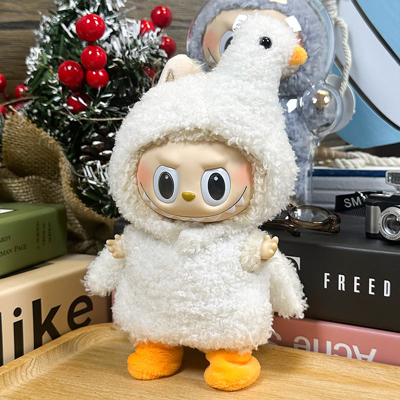 The ZoDoll Labubu White Fluffy Bird Kigurumi Doll Costume Set, made from bouclé loop fabric with a bird hood and orange feet, is displayed on a wooden surface near books and holiday decorations.