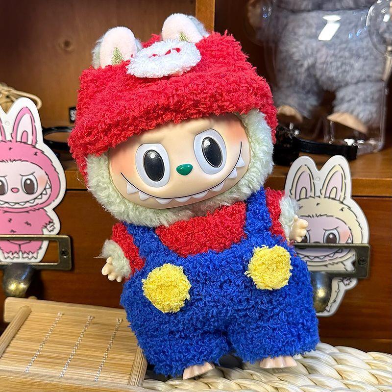 The ZoDoll Labubu Fluffy Plumber Costume Set features a plush doll with big eyes, a wide grin, bunny ears, and a red cap with blue overalls, posed in front of cartoon bunny stickers and wooden shelves.