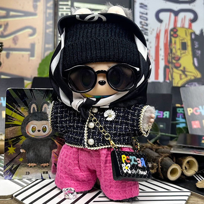 The ZoDoll Labubu Designer Tweed Jacket and Hot Pink Pants Luxury Doll Outfit Set features Labubu in a black beanie, sunglasses, black-and-white scarf, tweed jacket, pink pants, and holding a small handbag amid colorful decorations.