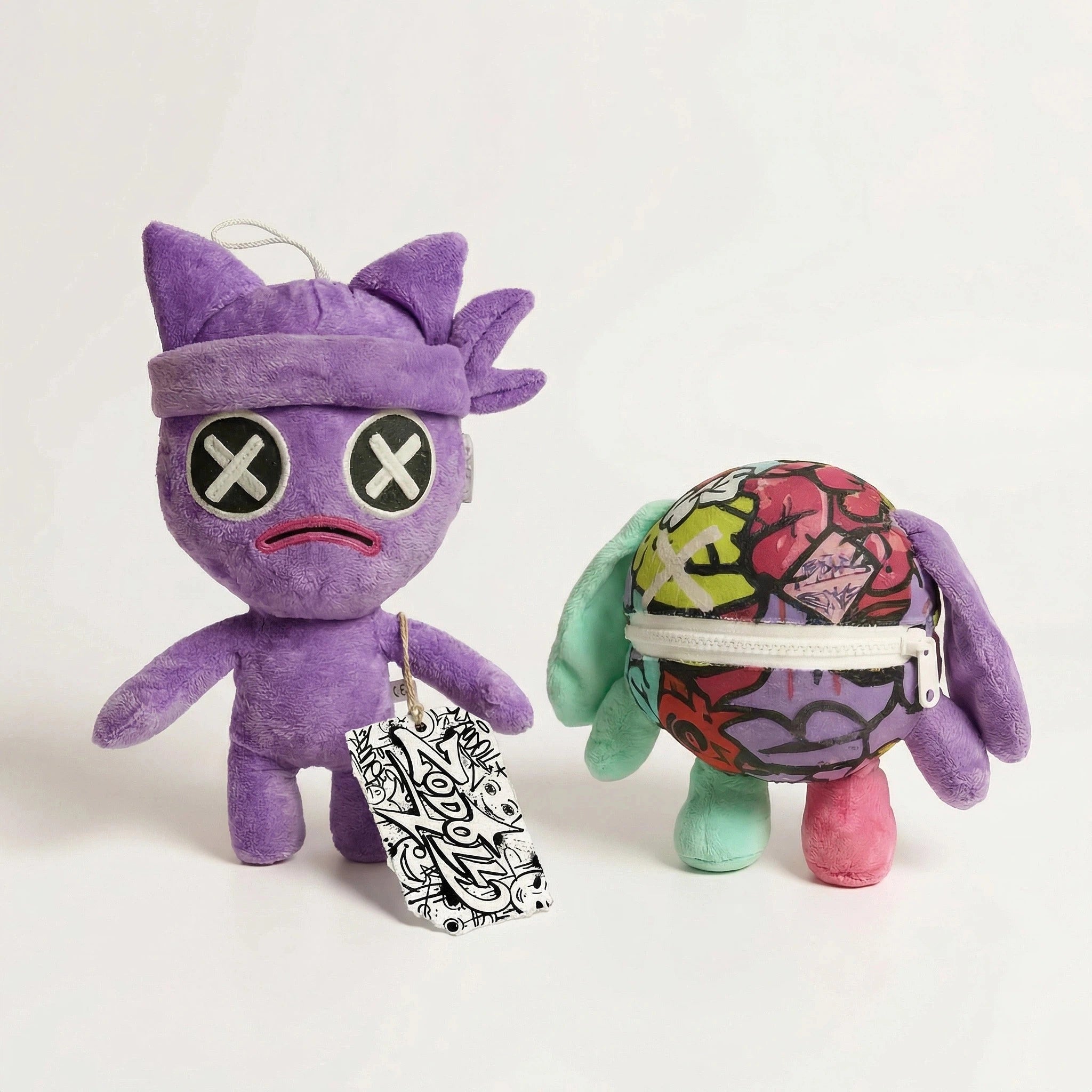 Two ZoDoll Poppy Playtime Chapter 5 Wrongside Outimals Reversible Plush toys: purple with headband and X eyes, and a round multicolored ball-to-beast plush with zipper mouth and floppy ears. Great for fans; tags attached.