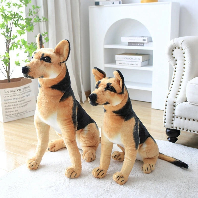 Two ZoDoll German Shepherd Plush Realistic Stuffed Dog Toys (30cm-90cm) sit on a wooden floor in a bright living room near a white shelf and green plant.