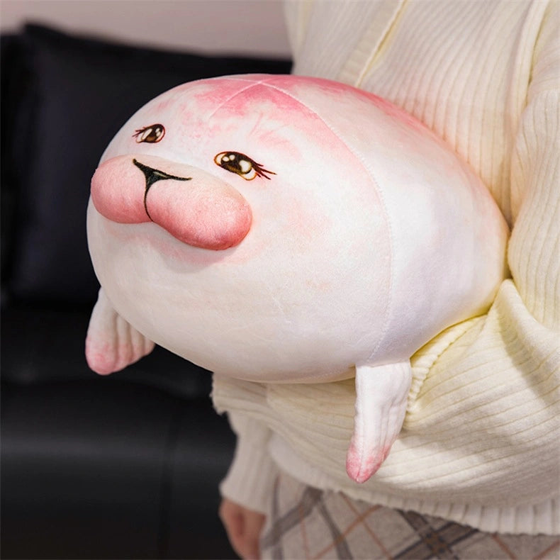 A person holds a ZoDoll Seal Plush Toy—a cute, chubby, pink and white stuffed seal pillow (20cm/40cm) with blushing cheeks and small flippers.