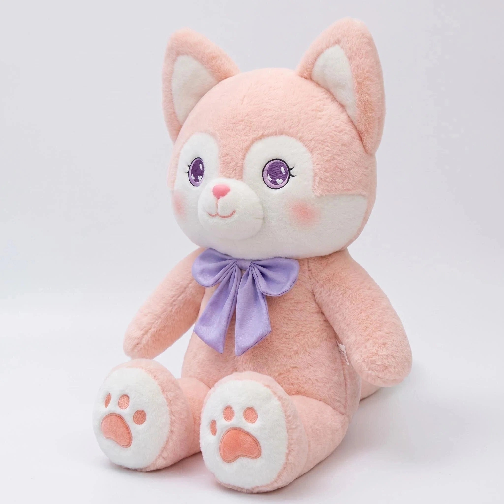 The ZoDoll Pink Fox Plush is a cute plush doll with a kawaii face, large purple eyes, white belly and paws, and a purple bow, sitting upright against a plain white background.