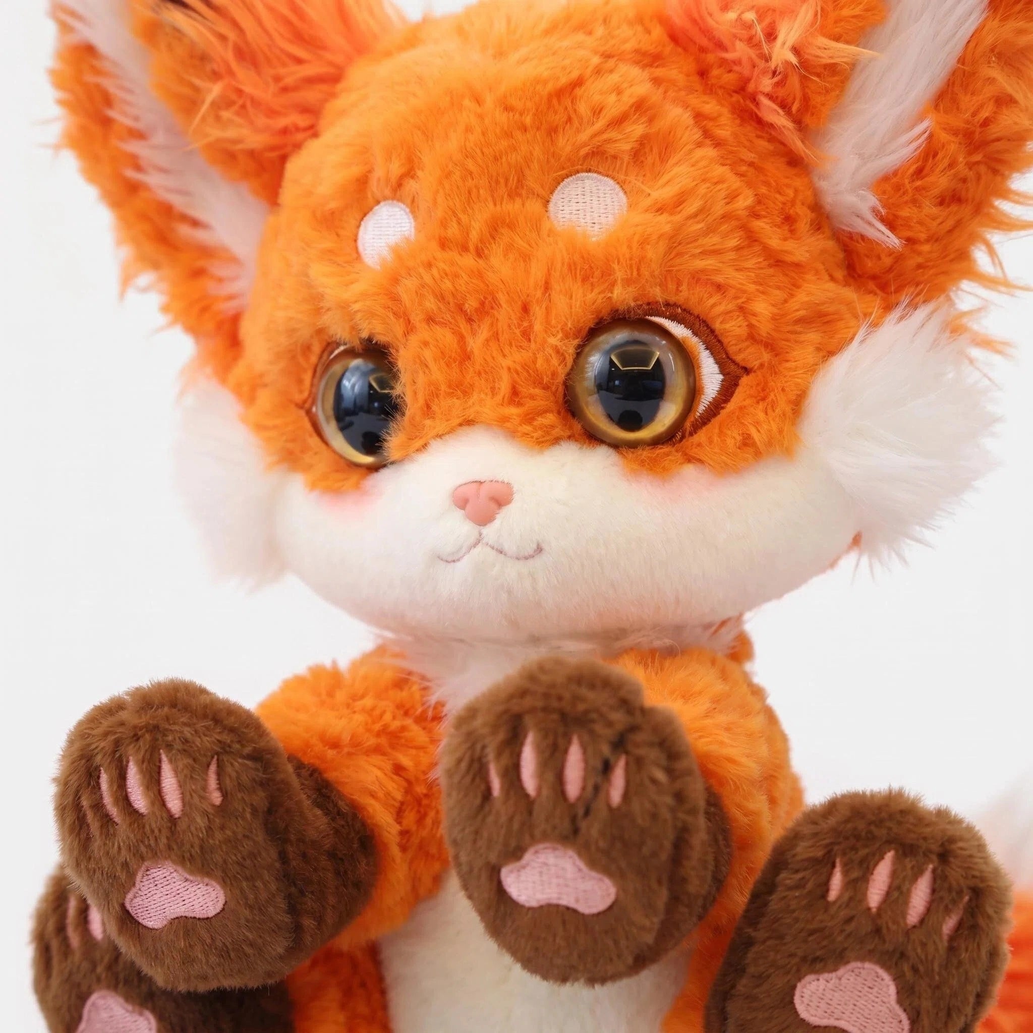 The ZoDoll Cute Fox Plush Toy is a red fox stuffed animal with big ears, large blue eyes, white cheeks, and brown paw pads, sitting upright and facing forward against a white background.