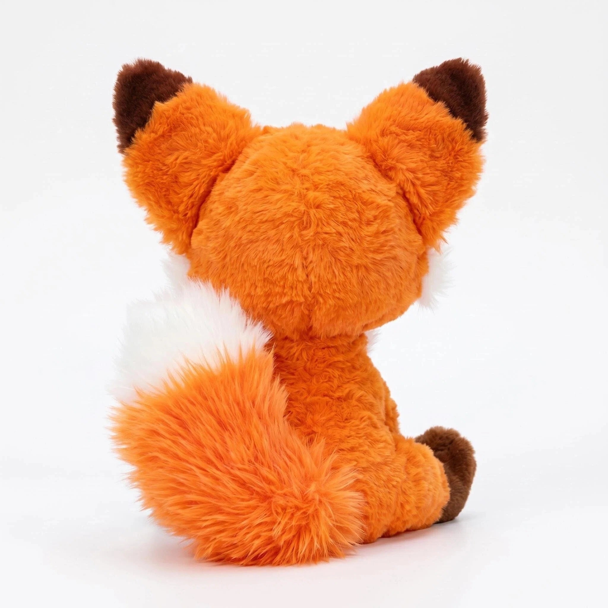 The ZoDoll Cute Fox Plush Toy, a red fox stuffed animal with big ears, sits back to the camera, showing off its soft bushy tail and adorable design.