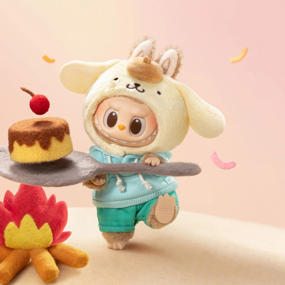 The POP MART LABUBU Hello Kitty and Friends Series Pompompurin Plush Pendant Figure features Pompompurin in a dog costume, holding a tray with flan and cherry, beside a felt campfire with colorful snacks—a delightful Sanrio collectible.